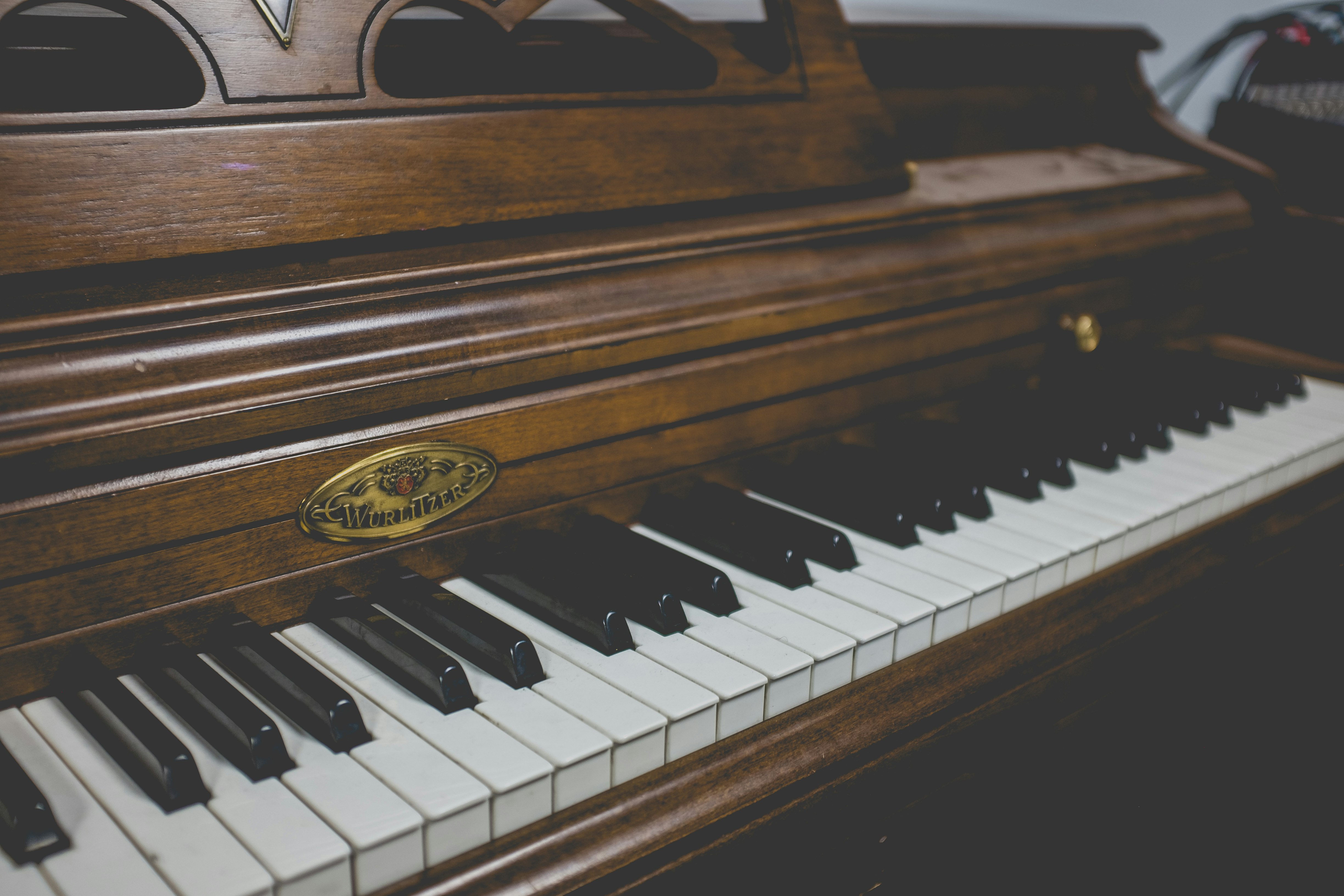 selective focus photography of brown and white upright piano